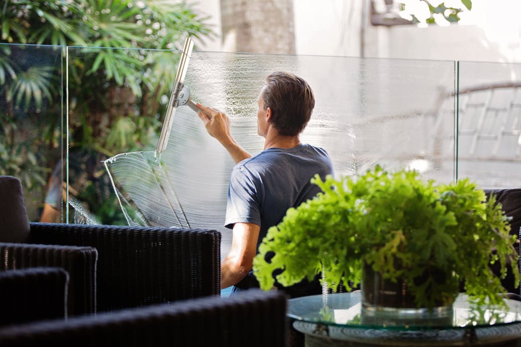 man cleaning a glass window